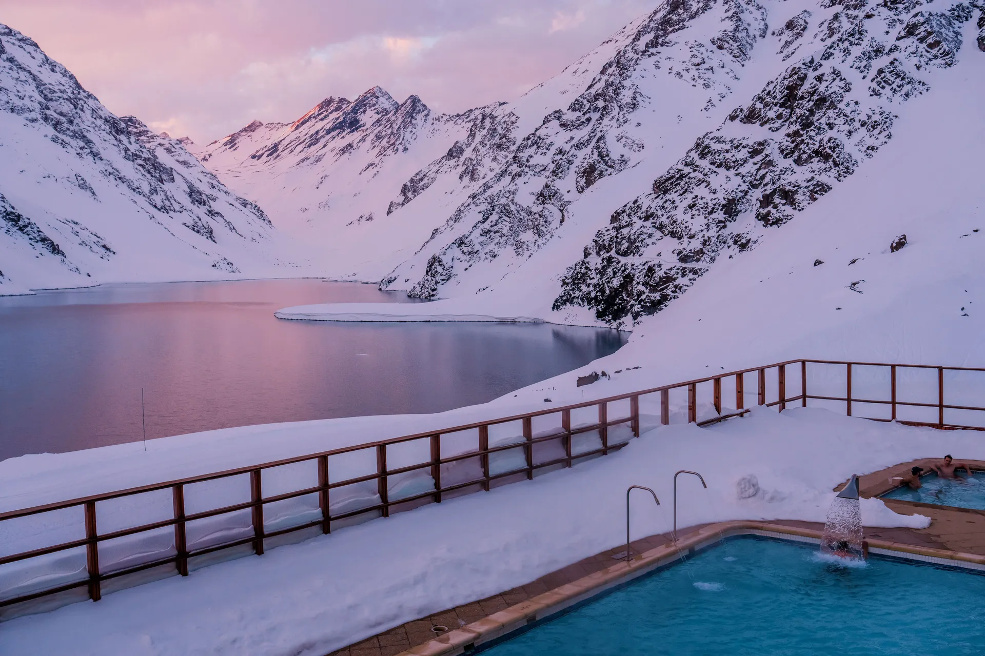 Pink sunset over mountains with pool