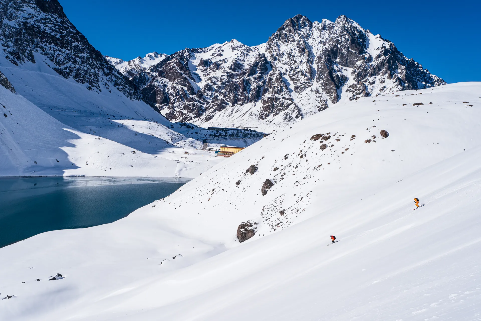 Duo descending with epic mountain panorama